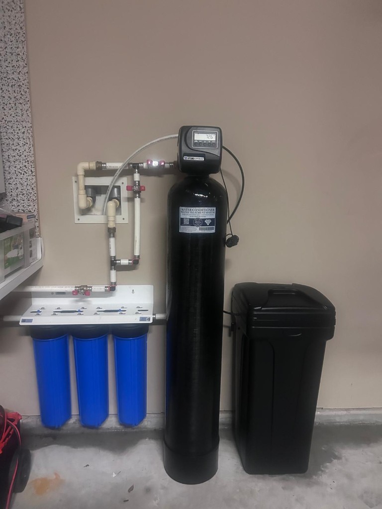 Water softener with 3-stage whole-home pre-filter and brine tank installed in a garage