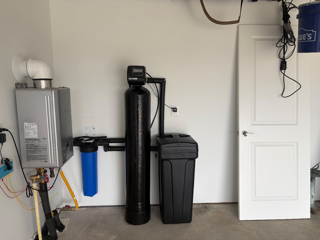 Water softener with whole-home pre-filter installed next to a tankless water heater