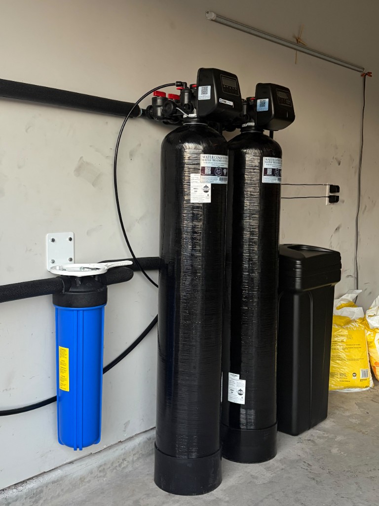 Twin-tank softener and carbon filtration system installed in a garage