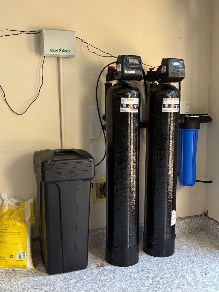 Twin-tank water softener and catalytic carbon system with pre-filter installed in a Houston garage